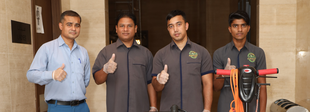 Four staff members with cleaning equipment